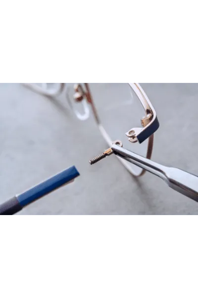 Eyeglass screw being replaced with precision tools